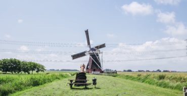 Een molen in een groen landschap.
