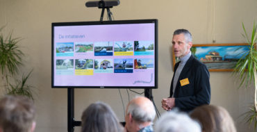 Een man staat rechts naast een presentatiebord