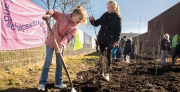 Kinderen met schep in hun hand scheppen in de aarde.